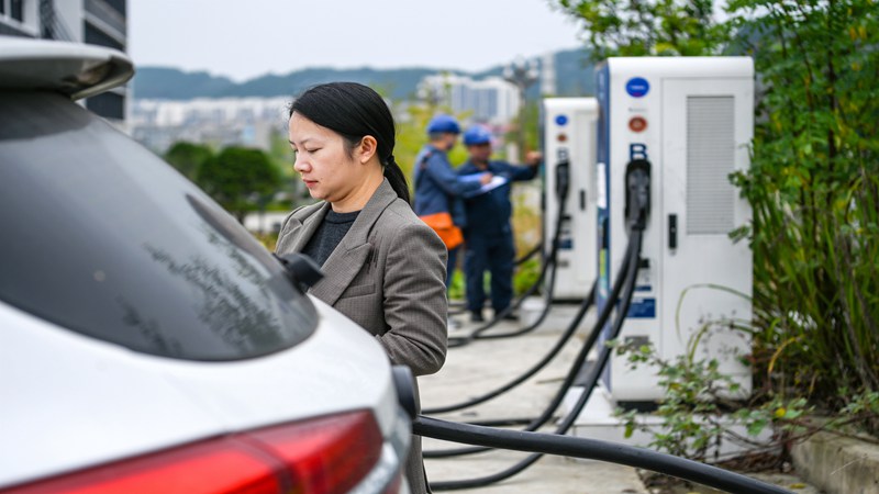 在黔東南州岑鞏縣溫泉社區電動汽車充電站，貴州電網公司凱裡供電局工作人員對場內的充電樁進行巡視檢查。楊啟志 攝