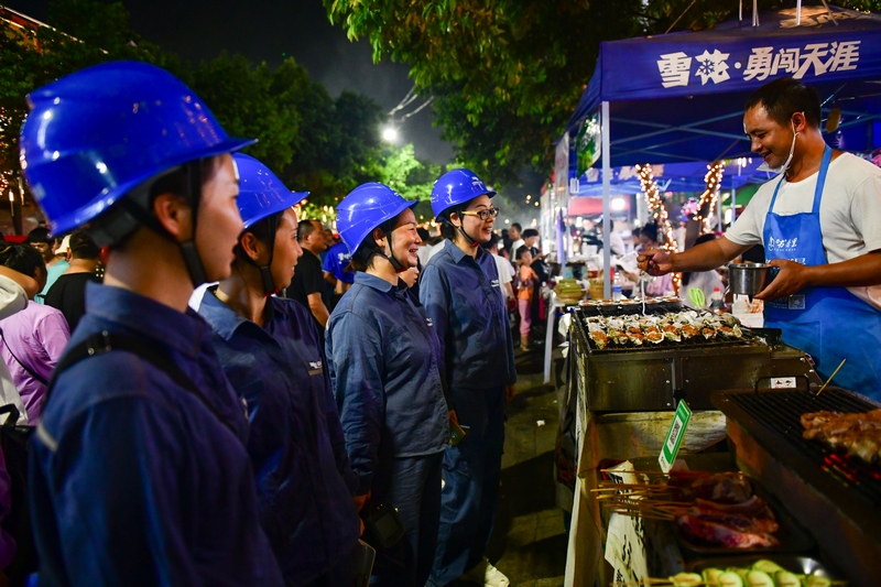凱裡榕江供電局工作人員對“村超”場外夜市街進行安全用電宣傳。胡乾 蒙萬剛攝
