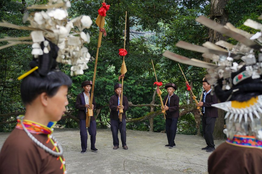 7月10日，贵州省丹寨县排调镇羊告村，王方元（左二）与苗族村民在跳锦鸡舞。