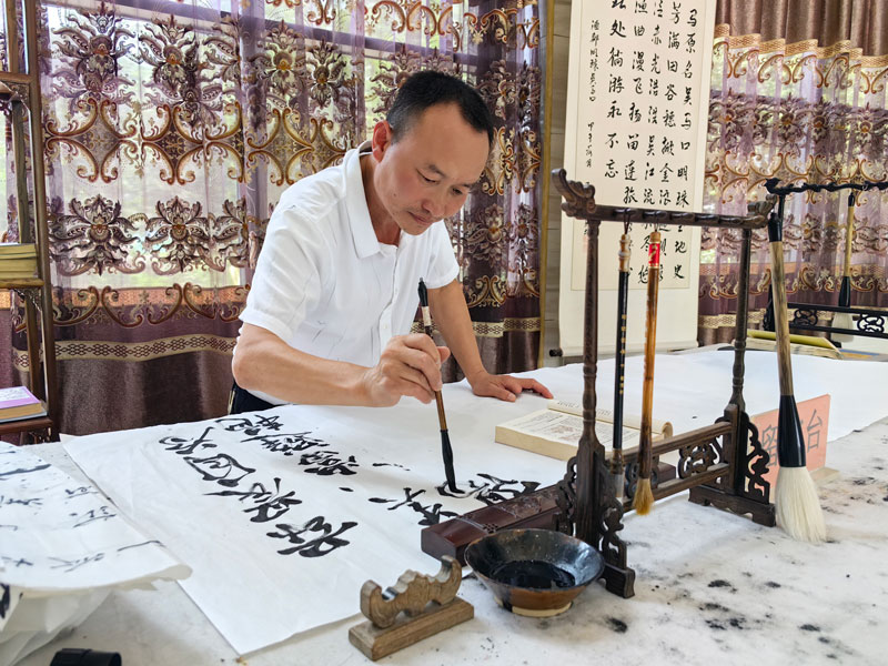 社区居民正在服务站练习书法。