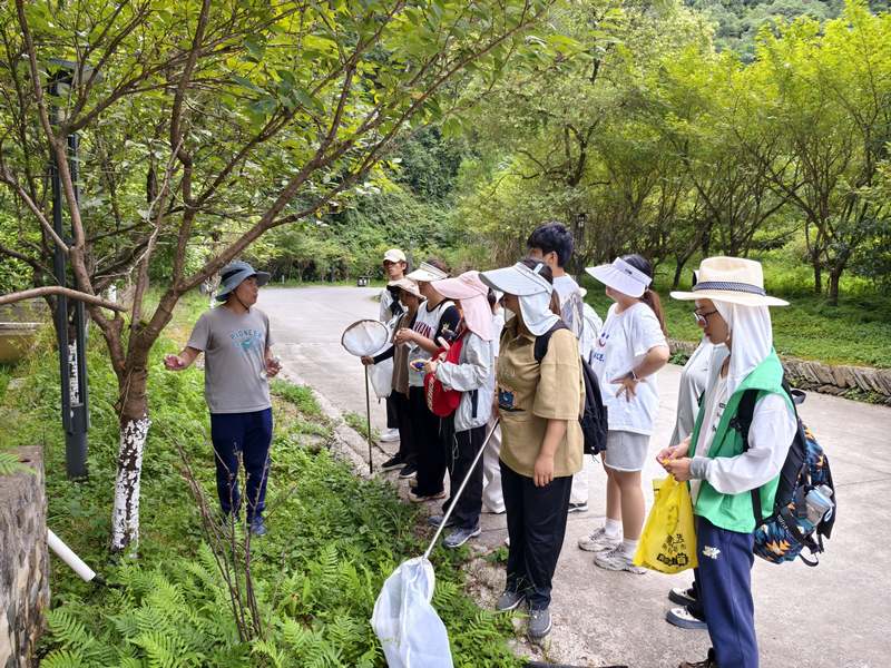 贵州大学植保系谢鑫老师在给学生讲解病虫害情况。