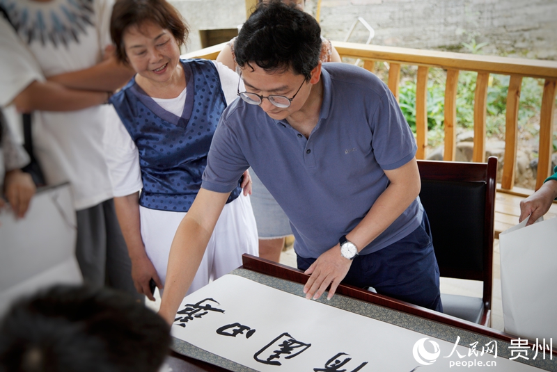 书画艺术家为村民创作字画。人民网 龙章榆摄