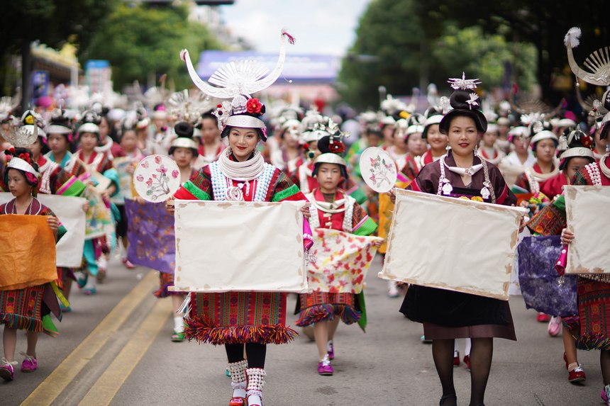 7月21日，贵州省丹寨县身着传统盛装服饰的群众，在展示国家级非遗项目皮纸制作技艺作品。