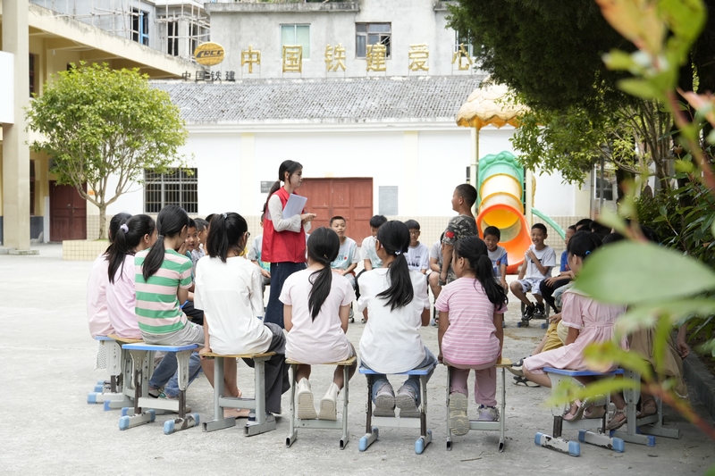 大河坝镇酸汤小学的大学生志愿者正在带领孩子们做游戏。