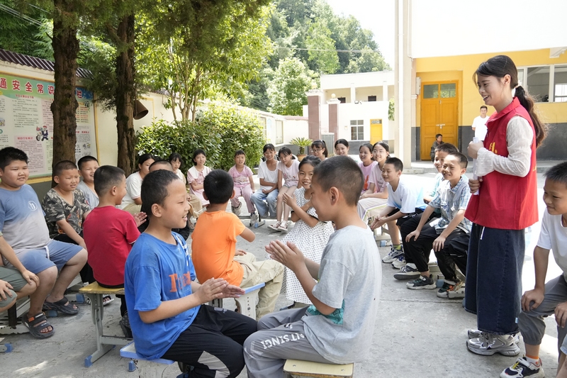 大河坝镇酸汤小学的大学生志愿者们正在带领孩子们做游戏。