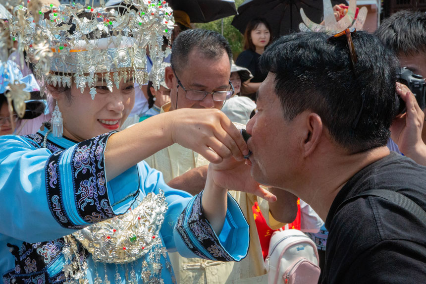 水族姑娘邀请客人喝九阡酒。实习生 袁华强摄