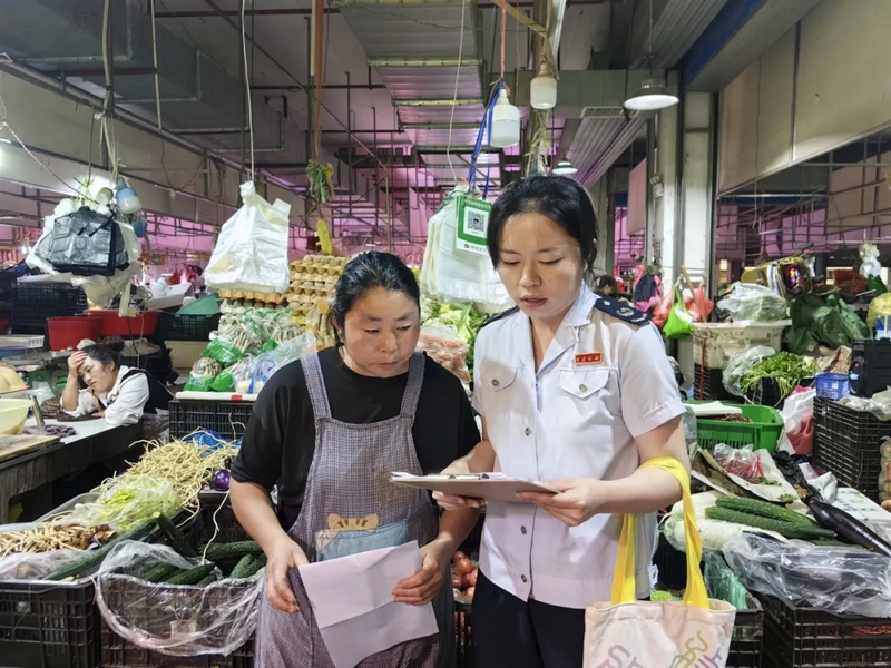 图为税务干部走进农贸市场辅导纳税人开具发票（沈金梅摄）