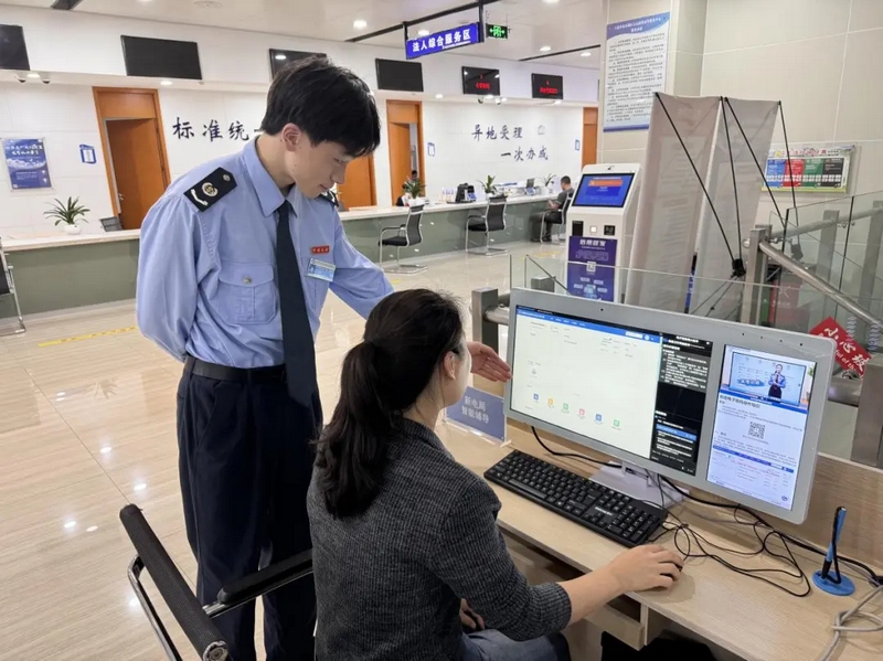 图为该局税务人员辅导纳税人体验智能辅导终端