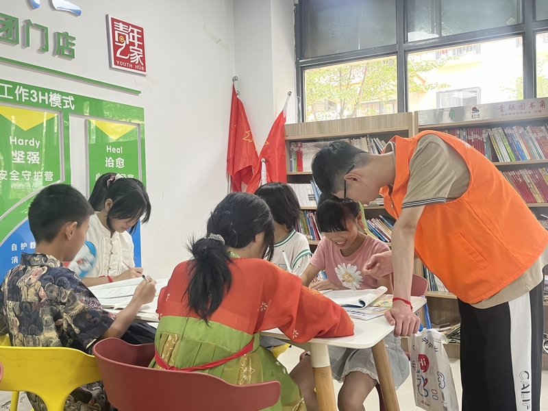 1、志愿者辅导孩子写作业。