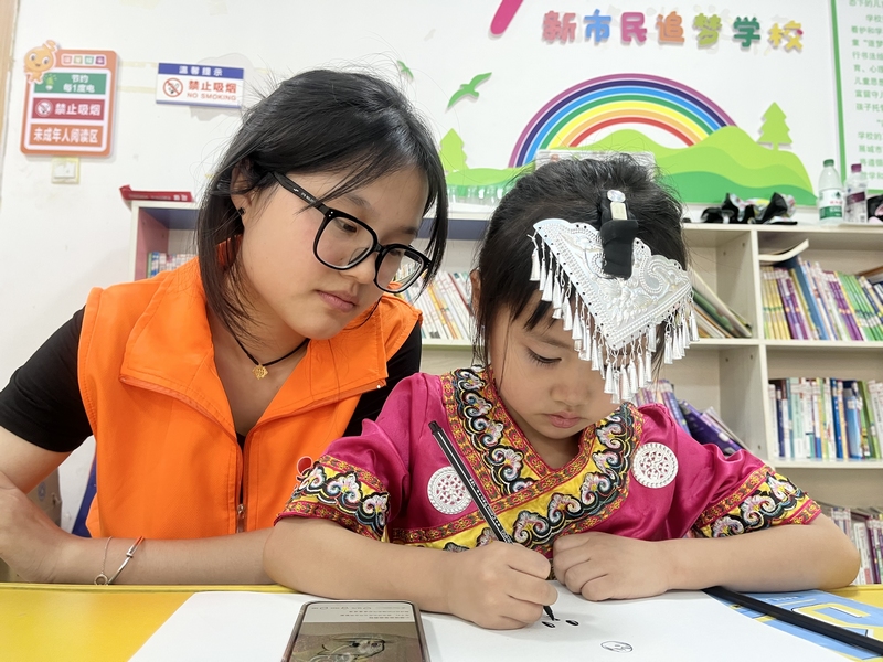 4、志愿者辅导孩子画画。