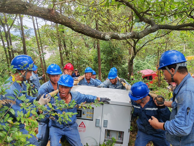 贵州电网公司遵义务川供电局组织施工人员采取人工挑运方式将配变计量设备运输到作业现场。王君辉 摄