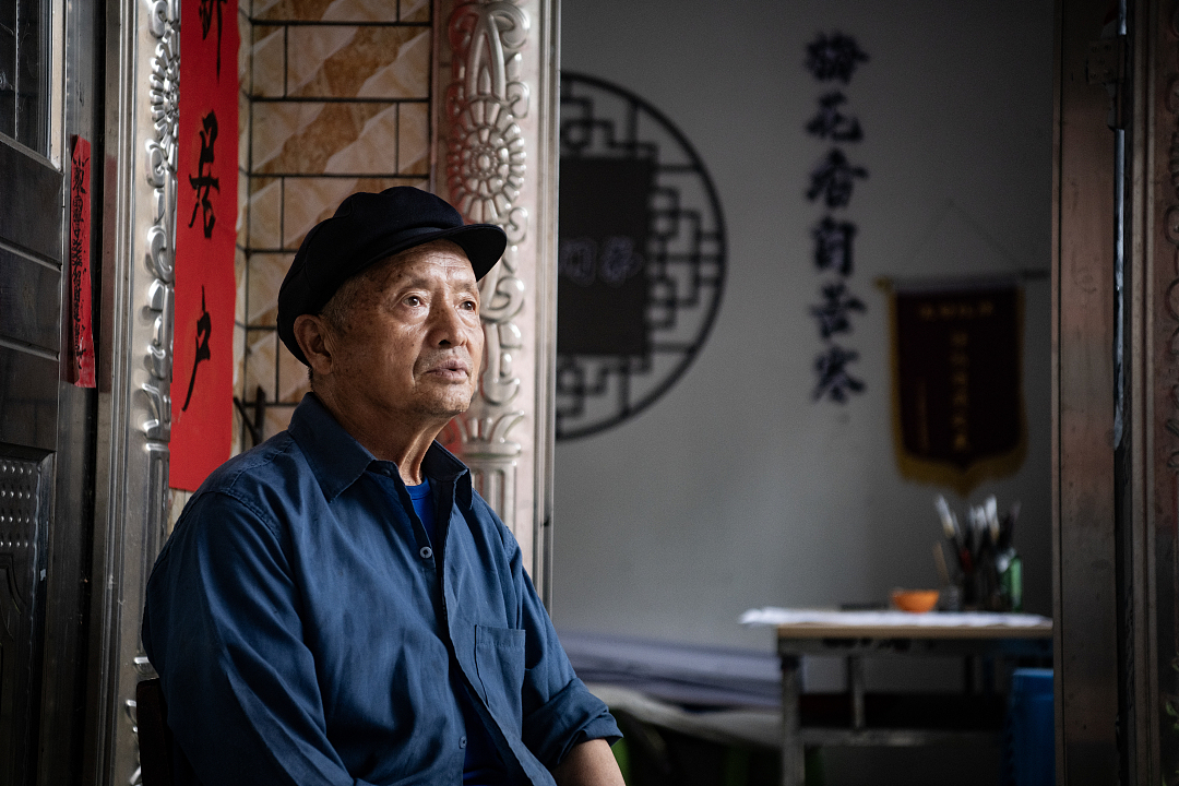 袁紹光坐在他的“三知書堂”前。