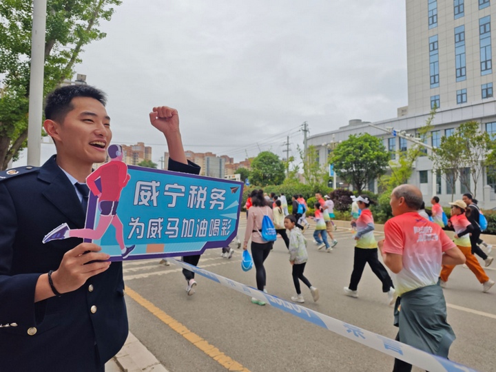 威寧馬拉鬆期間當地稅務人員為馬拉鬆運動員吶喊助威。韓瑾攝