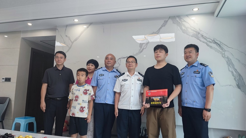 贵州警擦学院党委委员、副院长陈真波为欧嘉淋送去录取通知书。