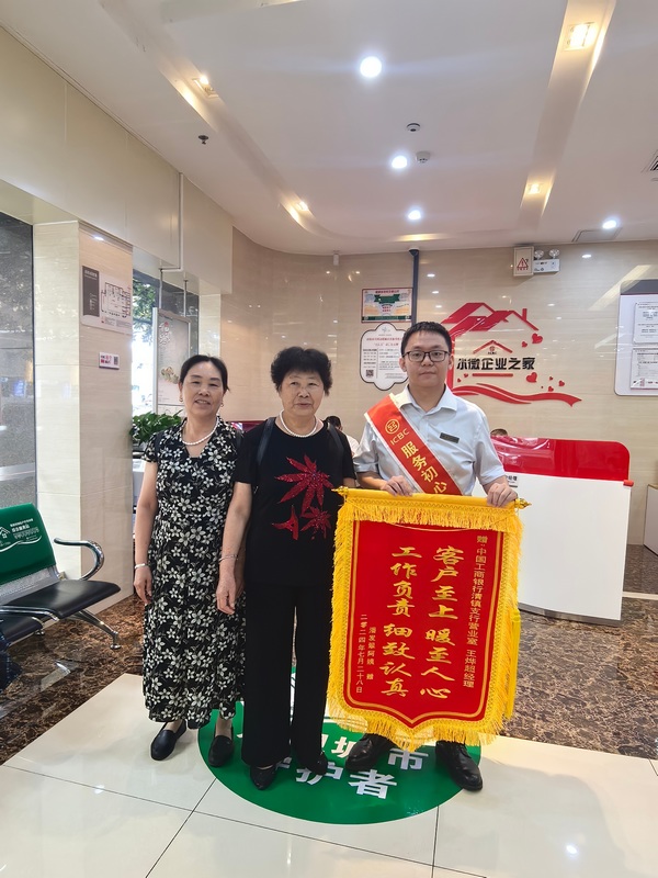 图为客户潘阿姨及其女儿为该行工作人员送锦旗，对他们负责地帮助其找回遗落的手机表示感谢。图由工行清镇支行提供.jpg
