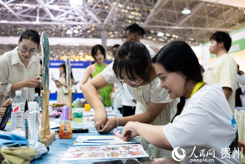 参会嘉宾体验农民画。人民网记者 涂敏摄