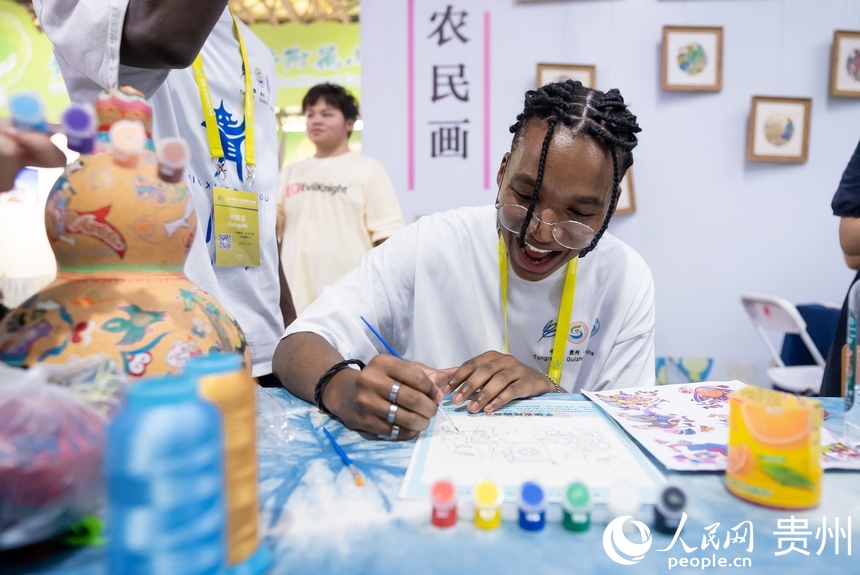 参会嘉宾体验农民画。人民网记者 涂敏摄