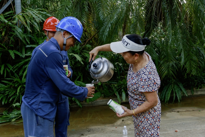 6、“小哥，你们衣服都湿透了，快来喝杯冰茶，降降温。”9月8日，在海南省文昌市白金路10千伏高隆线复电抢修施工现场，1名60多岁的林姓妈妈提着自制的当地“冰红茶”，挨个为南方电网贵州都匀供电局抢修施工队员送去，感谢贵州电网铁军的驰援义举。曹叡  摄