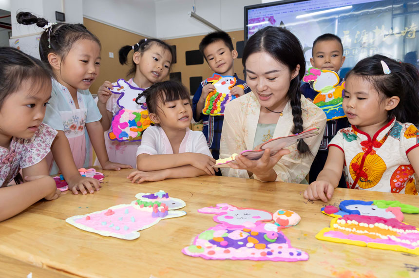 在罗甸县第一幼儿园，老师在指导小朋友制作玉兔画。