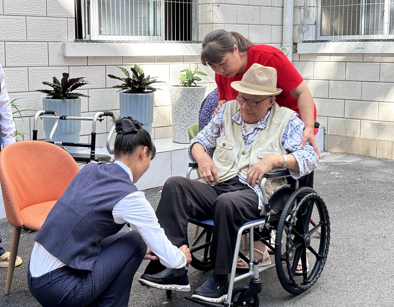 习水汇远医养中心工作人员为老人提供帮助。