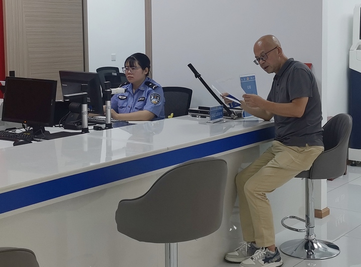 图为旅客在警务室窗口办理交管业务。