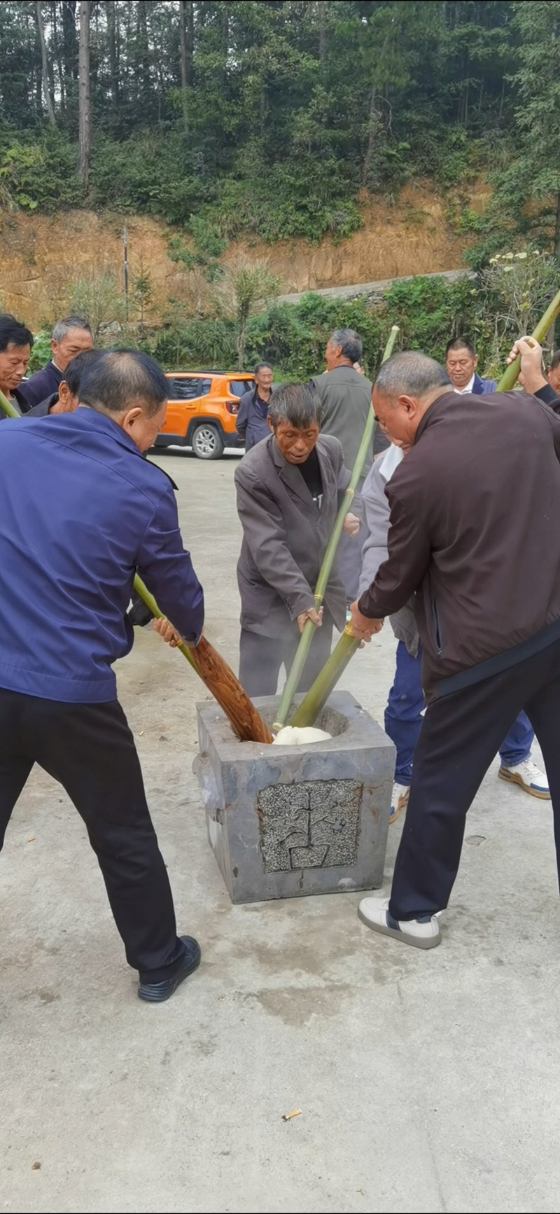 图为：南龙乡田坎村村民们正热火朝天打糍粑