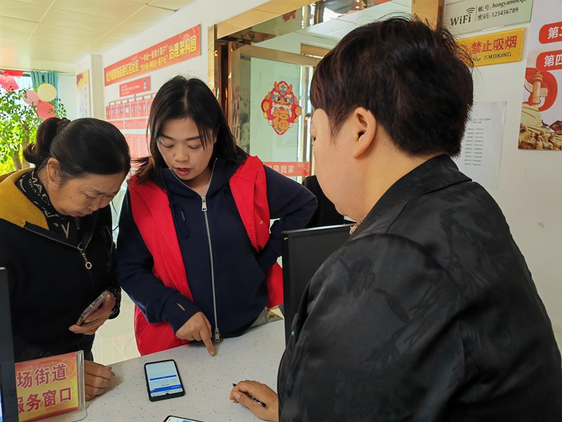 社區工作人員耐心地為居民解答有關醫保政策的疑問  黃源匯 攝 (2)