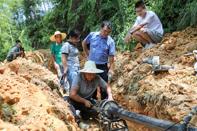 湘黔两省驻村工作队现场查看消防水池建设情况。