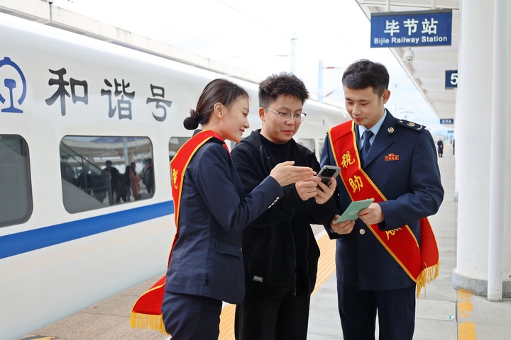 在高铁站，铁路+税务联合服务团队向旅客宣传“电子客票”并辅导开具。杨蝶摄