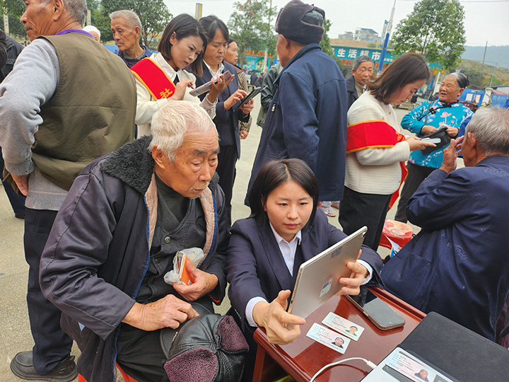 工作人員為老年客戶辦理養老保障待遇資格認証。