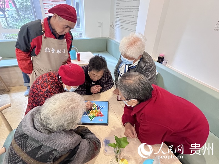 老人们趁开饭前展开了一场“激烈”的飞行棋比赛。人民网 陈洁泉摄