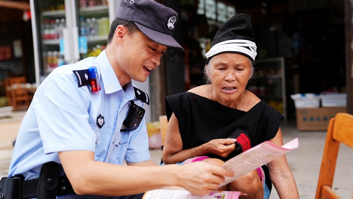 图为民警何亮亮向群众宣传反诈知识。