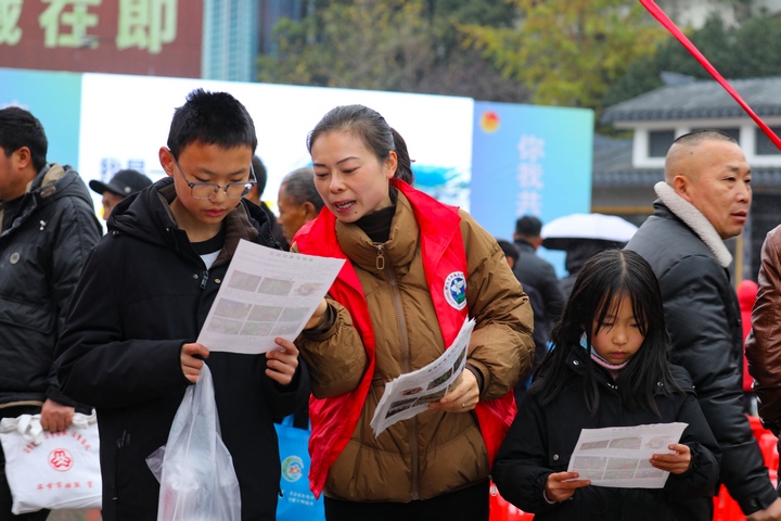 水西街道禁毒志愿者向现场群众讲解禁种铲毒相关法律知识。