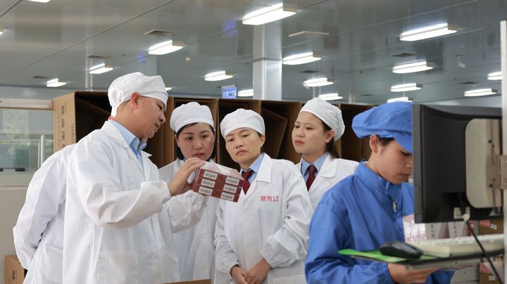 税务干部实地调研了解制药企业生产情况。