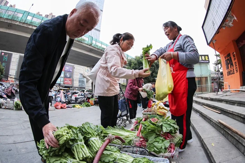 市民在邵叢英的攤位購買蔬菜。郭然攝