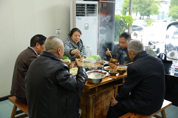 食客們圍坐一桌吃酸湯魚。謝達意攝