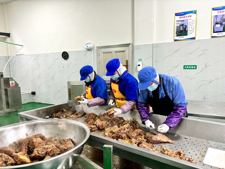 2、牛肉干加工廠內，工人對煮熟后的牛肉進行二次切割。