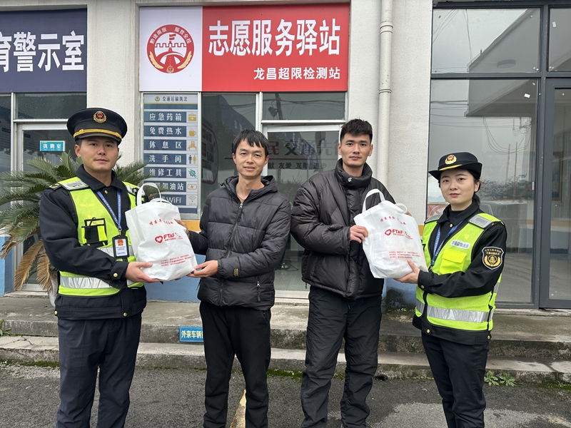 1 图为贵州交通综合执法人员向货车司机赠送暖冬礼包。