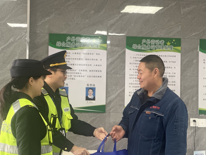 2 图为贵州交通综合执法人员向货车司机赠送暖冬礼包。