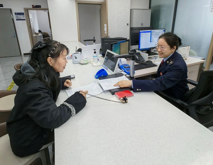 都勻市稅務局干部為居民講解契稅新政策。