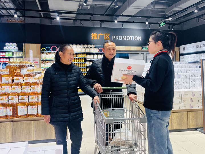 超市工作人員給市民介紹商品。