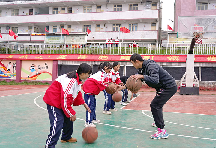 篮球社团老师在指导学生练习拍球。