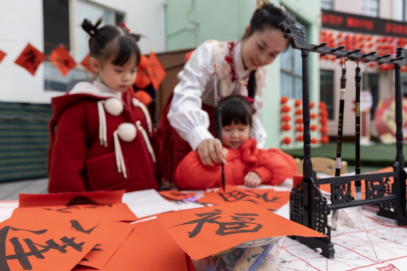 4 12月31日，在贵州省黔南布依族苗族自治州罗甸县莲花幼儿园开展的迎新年活动中，小朋友学习书法。 