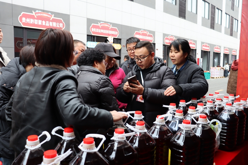 年货节摊位商家正在介绍产品。李宜桐摄