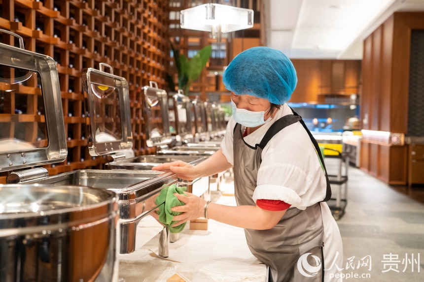 餐飲服務人員仔細擦拭布菲爐。人民網 陽茜攝