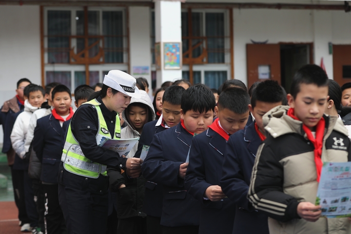 图为：2025年2月17日，雷山县公安局交警大队辅警邵月圆向学生发放讲解宣传资料1.JPG