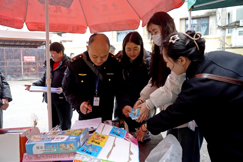 2025年2月17日，贵州省毕节市纳雍县第一小学旁，检查组在校园周边摊点收缴禁售书籍。杨英摄