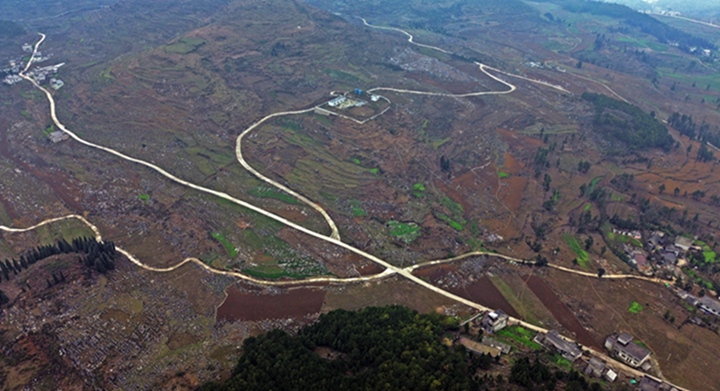 航拍贵州省黔西市铁石苗族彝族乡铁盔山村的机耕道与村庄、山峦、田地构成一幅生机盎然的田园画卷。  熊军万摄