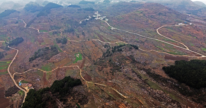 航拍贵州省黔西市铁石苗族彝族乡铁盔山村的机耕道与村庄、山峦、田地构成一幅生机盎然的田园画卷。  熊军万摄