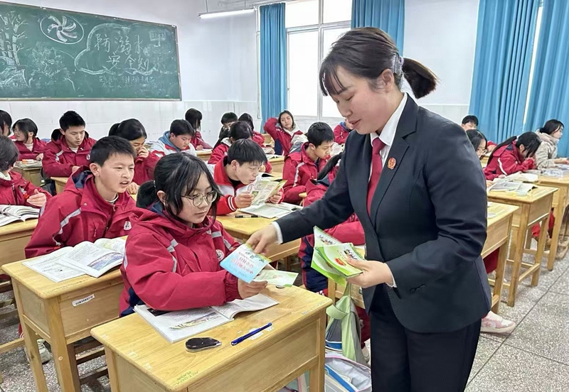 圖為：干警發放宣傳冊